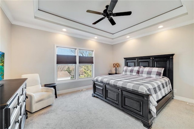 carpeted bedroom with a raised ceiling, ceiling fan, and ornamental molding