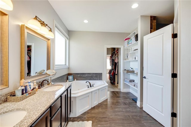 bathroom with vanity and a bath