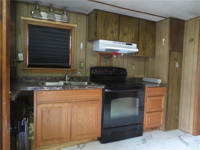 kitchen featuring black electric range, wooden walls, and sink