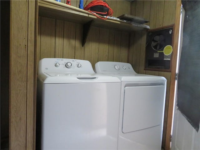 laundry area featuring washer and dryer and wood walls