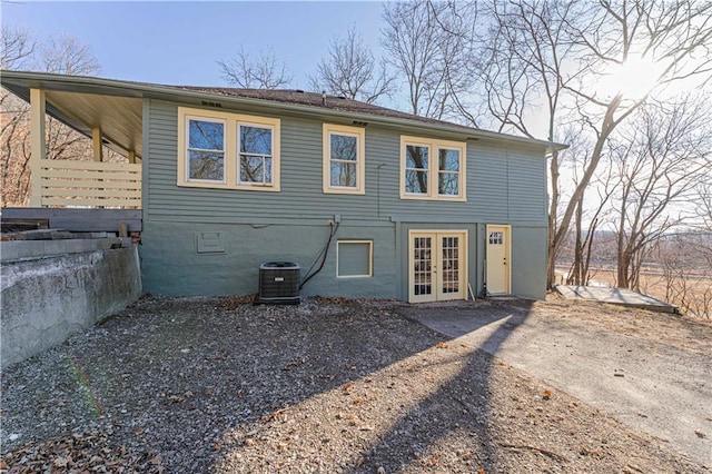 rear view of house with cooling unit and french doors