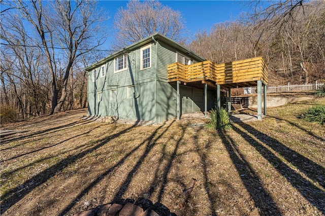 view of home's exterior with a wooden deck and a yard