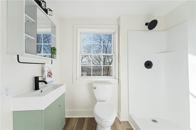 bathroom with vanity, toilet, hardwood / wood-style floors, and a shower