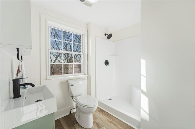 bathroom featuring walk in shower, wood-type flooring, toilet, and vanity