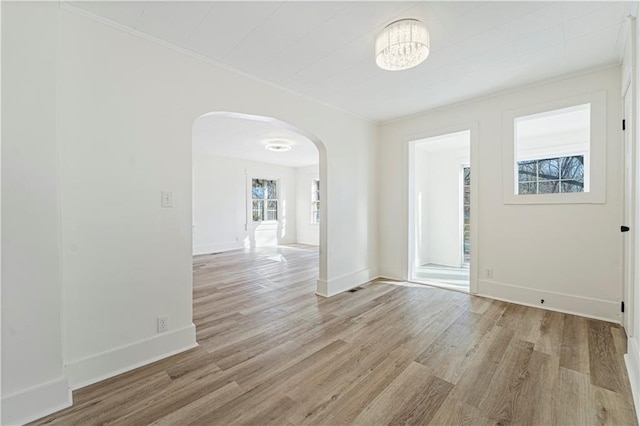 empty room featuring an inviting chandelier and light hardwood / wood-style floors