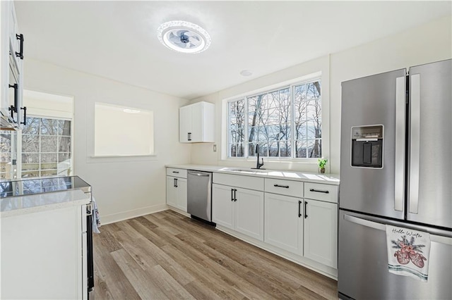 kitchen featuring white cabinetry, appliances with stainless steel finishes, sink, and light hardwood / wood-style floors