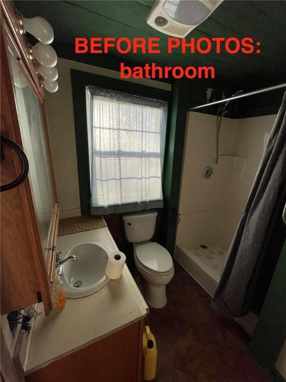 bathroom with toilet, vanity, and walk in shower