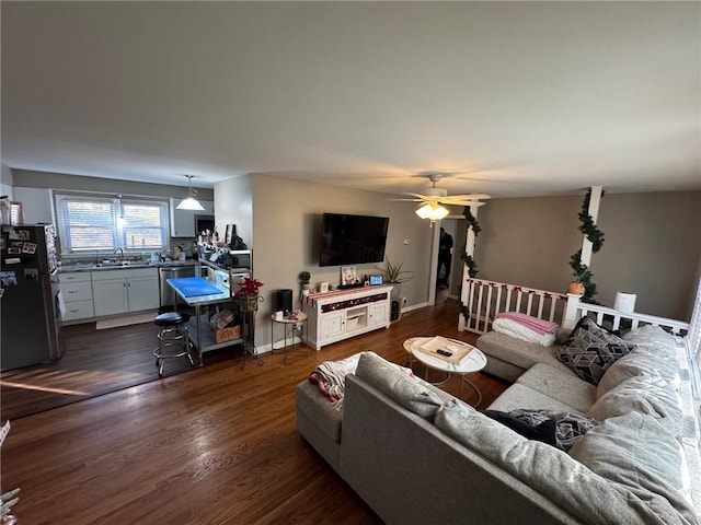 living room with dark hardwood / wood-style flooring, sink, and ceiling fan