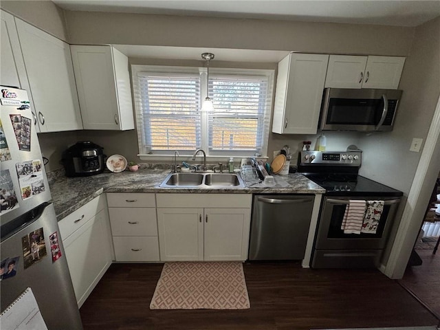 kitchen with appliances with stainless steel finishes, sink, dark wood-type flooring, and white cabinets