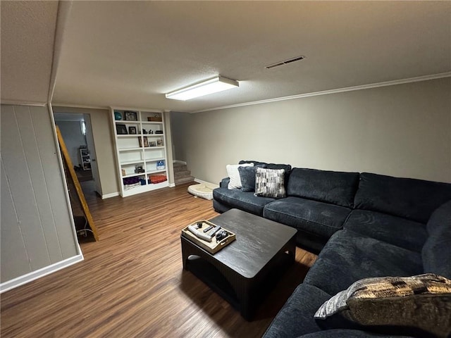 living room featuring crown molding, dark hardwood / wood-style floors, and built in shelves