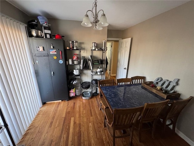 dining room featuring wood-type flooring and a notable chandelier