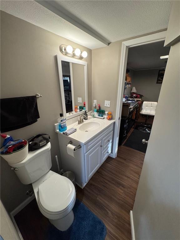 bathroom with wood-type flooring, vanity, a textured ceiling, and toilet