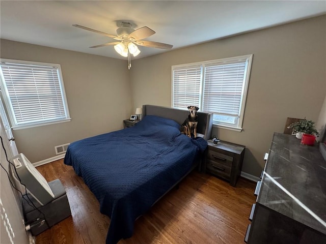 bedroom with dark hardwood / wood-style flooring and ceiling fan