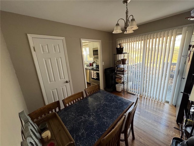 dining room featuring a notable chandelier and light wood-type flooring