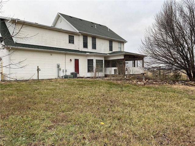 rear view of house with a lawn and cooling unit