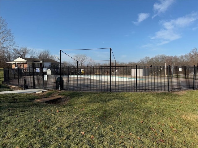 view of basketball court with a community pool and a lawn