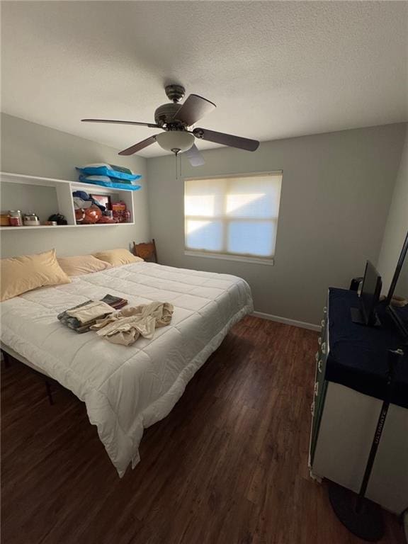 bedroom with ceiling fan, a textured ceiling, and dark hardwood / wood-style flooring