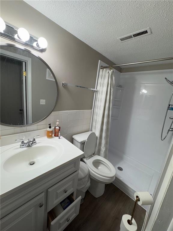 bathroom featuring vanity, tile walls, a textured ceiling, and a shower with curtain