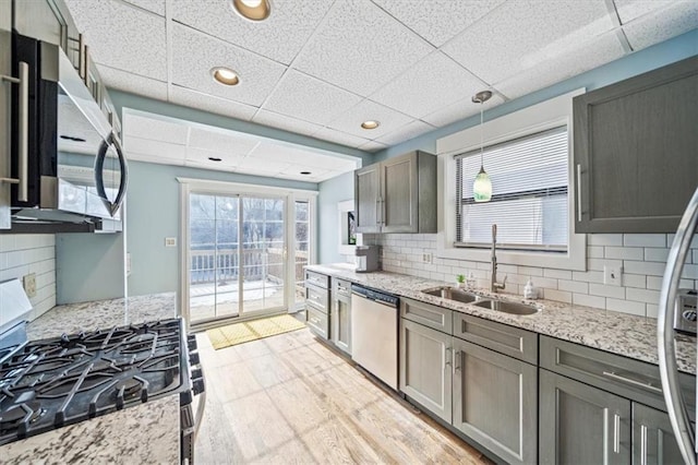 kitchen featuring sink, a paneled ceiling, appliances with stainless steel finishes, and tasteful backsplash