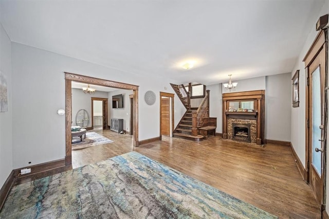 living room with radiator heating unit, an inviting chandelier, and hardwood / wood-style floors