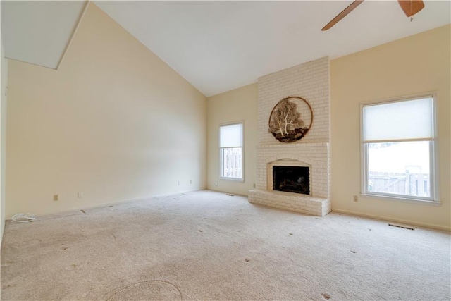 unfurnished living room with a fireplace, carpet, high vaulted ceiling, and ceiling fan