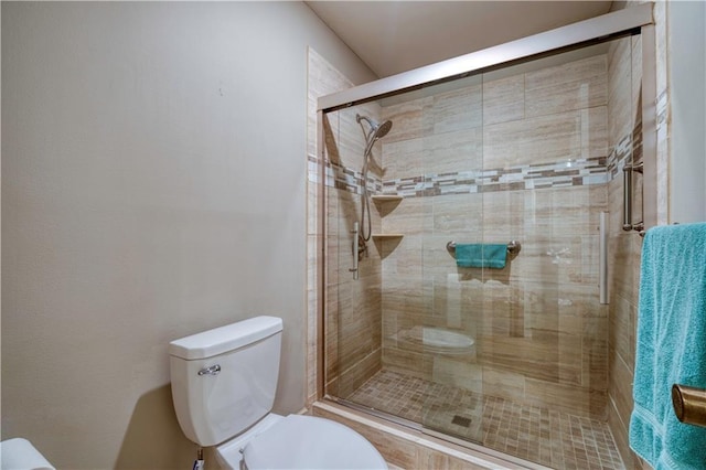 bathroom with a shower with door and toilet