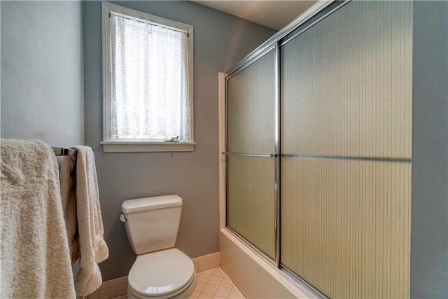 bathroom with tile patterned flooring, toilet, enclosed tub / shower combo, and a wealth of natural light