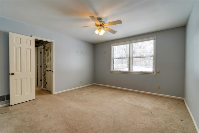 spare room with light colored carpet and ceiling fan