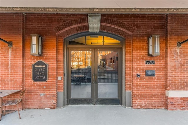 doorway to property featuring brick siding and french doors