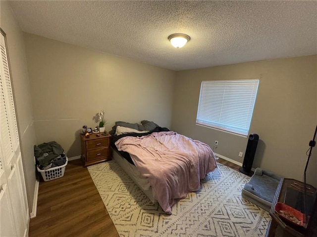 bedroom with a textured ceiling and light hardwood / wood-style flooring