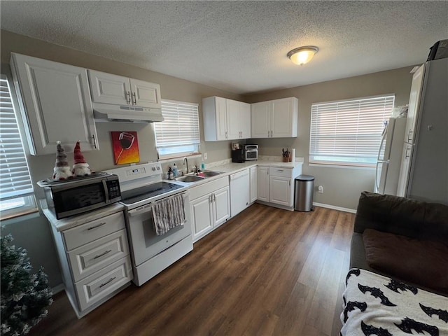 kitchen with dark hardwood / wood-style floors, white cabinetry, sink, and white appliances