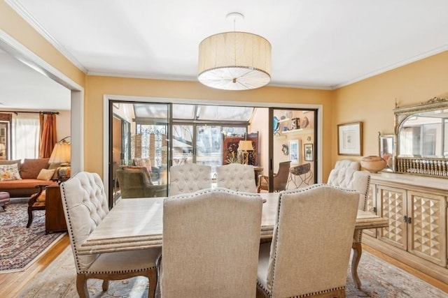 dining area featuring crown molding and light hardwood / wood-style floors