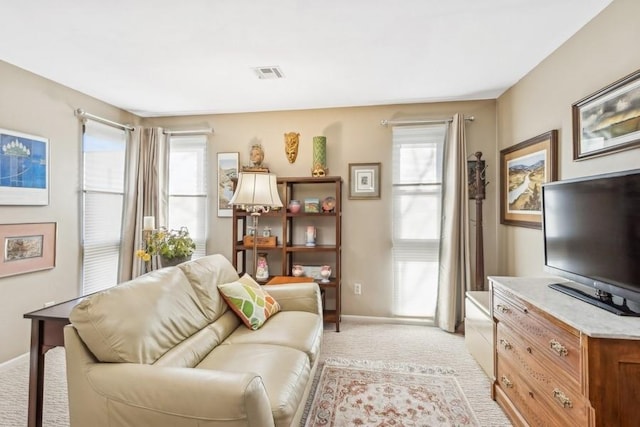 living room featuring light colored carpet and a healthy amount of sunlight