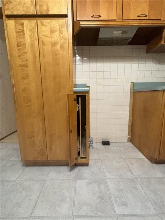 interior space with light tile patterned flooring and exhaust hood