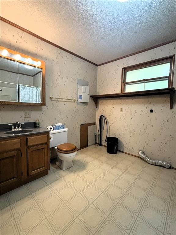 bathroom featuring curtained shower, a textured ceiling, toilet, vanity, and ornamental molding