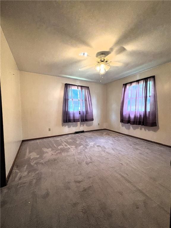 carpeted spare room with ceiling fan and a textured ceiling