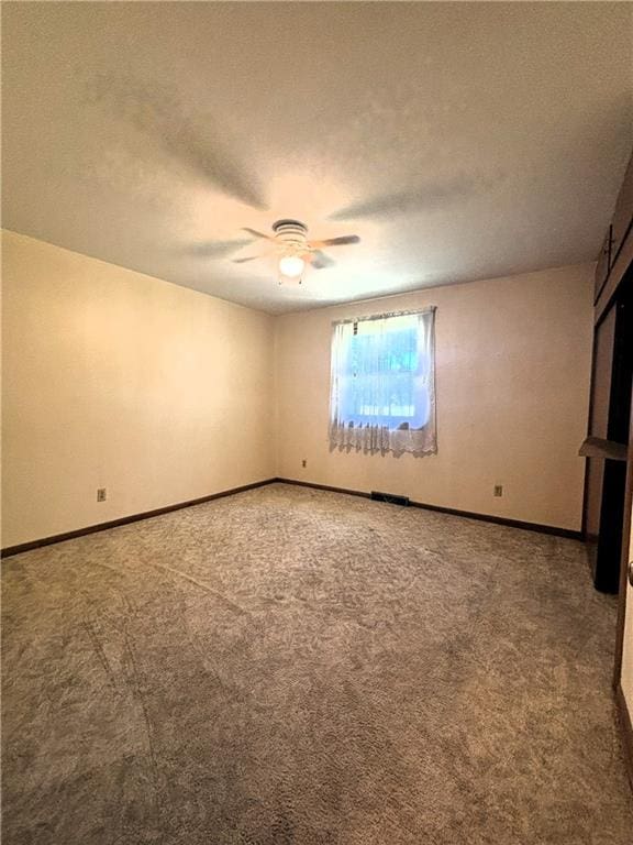 spare room featuring carpet, a textured ceiling, and ceiling fan