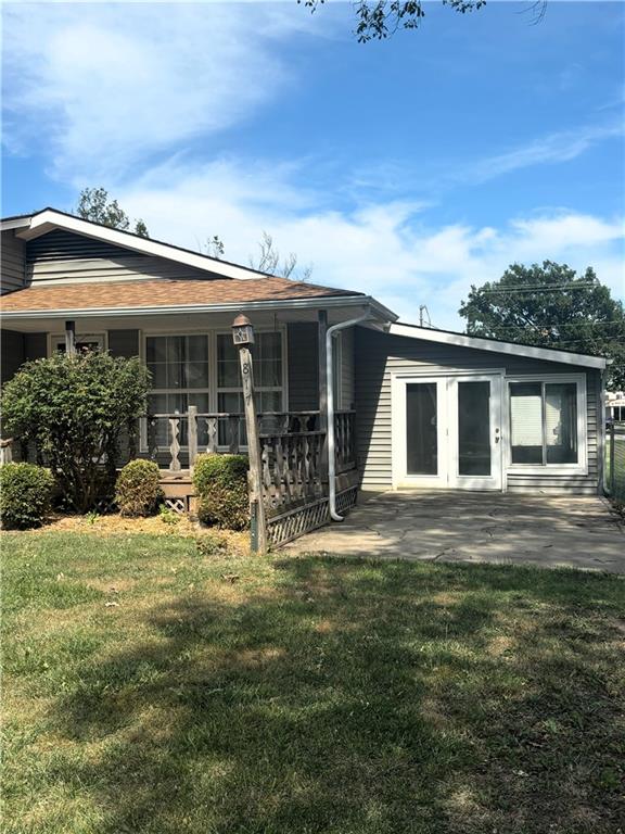 rear view of property featuring a patio area and a yard