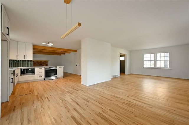 unfurnished living room with beamed ceiling and light hardwood / wood-style floors