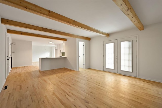 unfurnished living room with beam ceiling, french doors, and light hardwood / wood-style floors