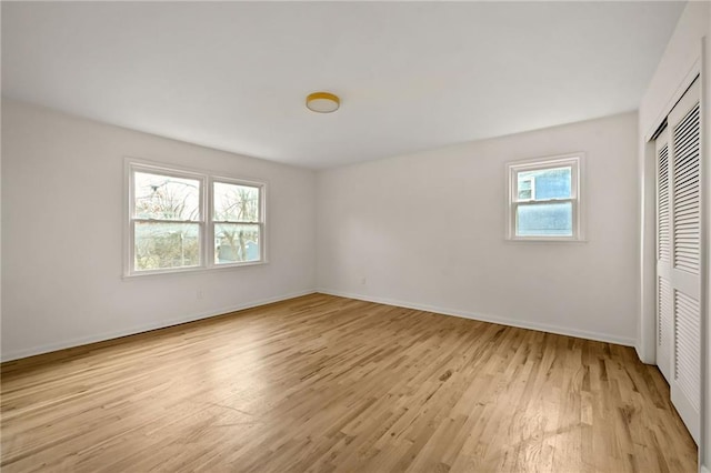 unfurnished bedroom featuring light wood-type flooring and a closet