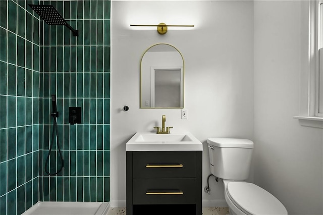 bathroom with vanity, toilet, and a tile shower