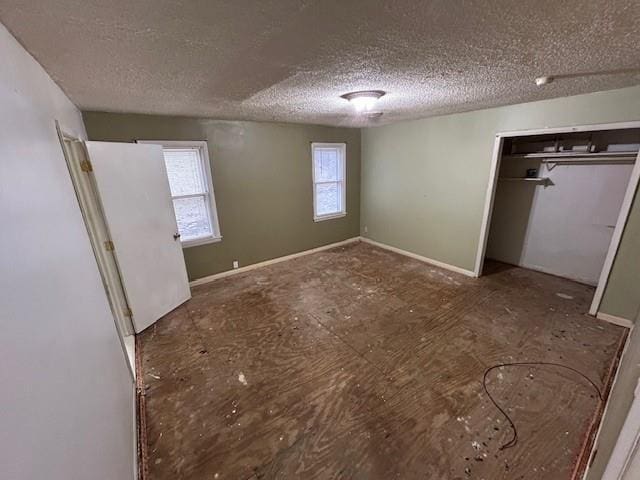 unfurnished bedroom featuring multiple windows, a closet, and a textured ceiling