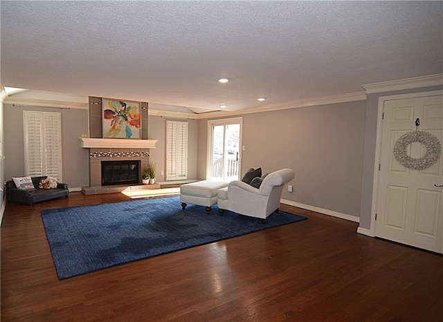 unfurnished living room featuring crown molding, a textured ceiling, a fireplace, and dark hardwood / wood-style flooring