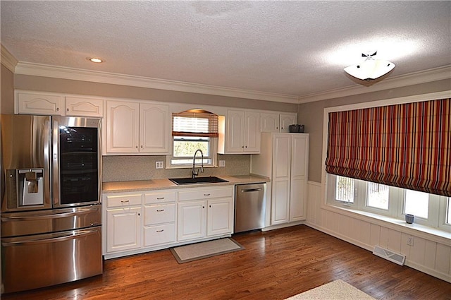 kitchen featuring sink, dark wood-type flooring, white cabinets, and appliances with stainless steel finishes