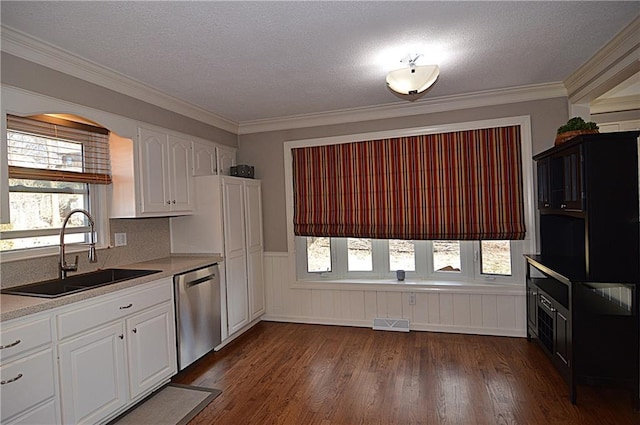 kitchen with dark wood-type flooring, stainless steel dishwasher, sink, and white cabinets