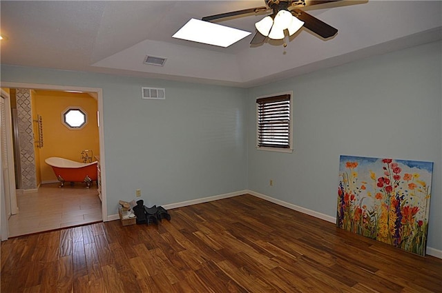 spare room featuring ceiling fan, dark hardwood / wood-style floors, and a raised ceiling