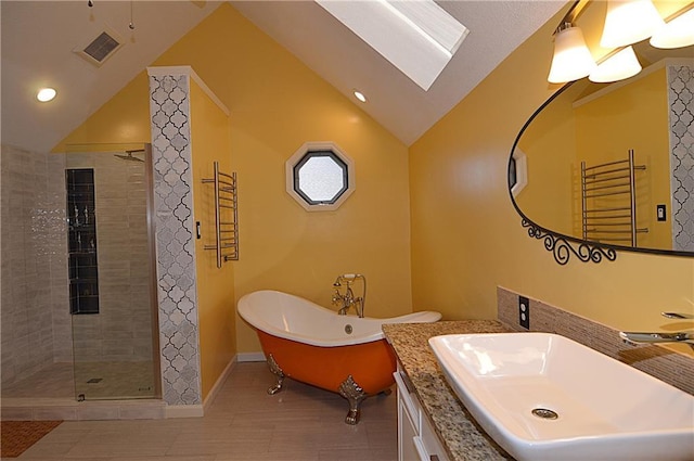 bathroom with vaulted ceiling, separate shower and tub, and sink