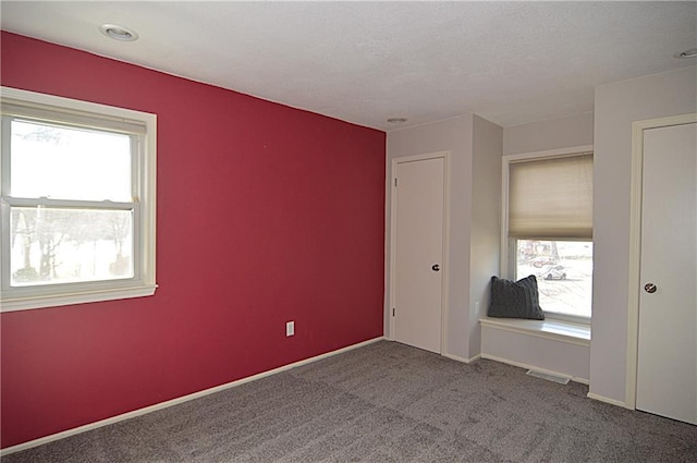 unfurnished bedroom featuring carpet flooring and multiple windows