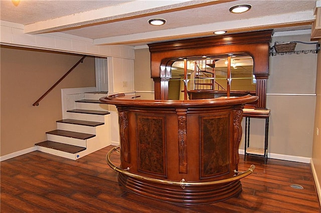 bar featuring dark wood-type flooring, a textured ceiling, and beam ceiling